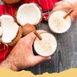 The Ultimate Guide to Authentic Puerto Rican Coquito: A Taste of Holiday Tradition 6 A glass of creamy Authentic Puerto Rican Coquito garnished with a cinnamon stick and sprinkled with cinnamon, set against a festive holiday backdrop.