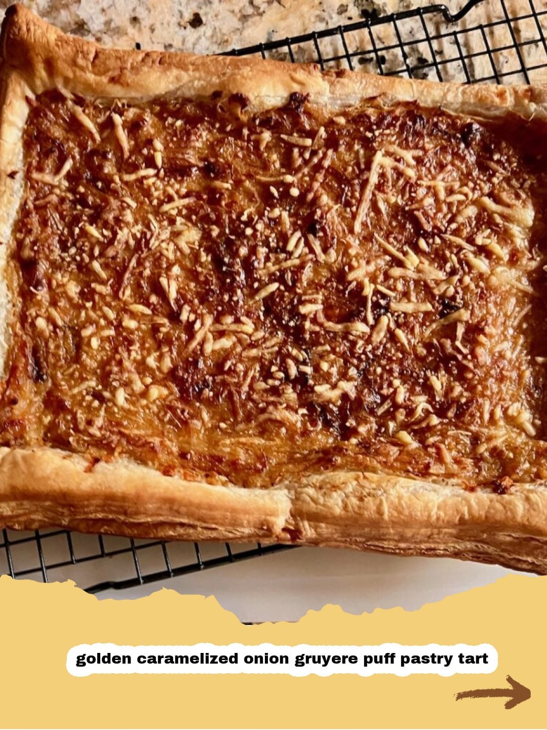 The Ultimate Caramelized Onion and Gruyere Cheese Tart Recipe 1 A golden-brown caramelized onion and gruyere cheese tart, sliced and ready to serve on a rustic wooden board, with fresh thyme garnish.