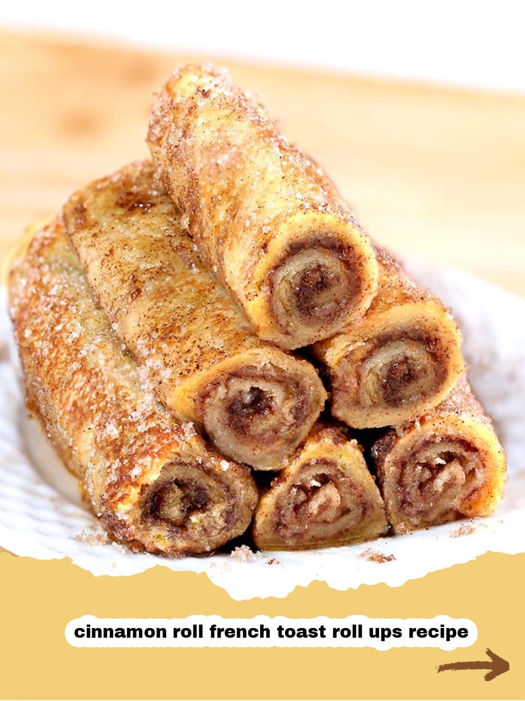 Irresistible Cinnamon French Toast Roll Ups: Your New Favorite Breakfast Treat! 1 Pile of golden brown Cinnamon French Toast Roll Ups dusted with powdered sugar and drizzled with maple syrup, next to fresh berries.