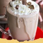Two glasses of creamy, frothy frozen hot chocolate topped with whipped cream, chocolate shavings, and mini marshmallows.