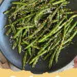 The Absolute Best Quick Blistered Green Beans Recipe for Any Meal 6 A close-up of vibrant green blistered green beans in a cast iron skillet, garnished with fresh lemon wedges.
