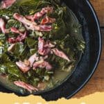 A large pot of perfectly cooked Southern Style Collard Greens with smoked ham hocks.