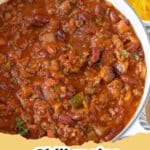 The Ultimate Deep-Dive: Crafting The Best Chili Recipe Ever 9 A close-up of a steaming bowl of homemade chili, garnished with shredded cheddar cheese, a dollop of sour cream, and fresh green onions.