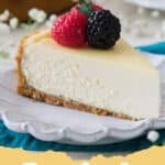 Unlocking the Secret to The BEST Cheesecake Recipe Ever: Your Guide to Perfection 5 A perfectly baked, crack-free New York style cheesecake on a white serving plate, garnished with fresh mixed berries.