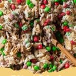 The Ultimate Homemade Chex Christmas Mix: A Holiday Tradition Made Easy 5 A large bowl filled with golden brown Chex Christmas Mix, featuring Chex cereals, pretzels, mixed nuts, and bagel chips, garnished with fresh rosemary.