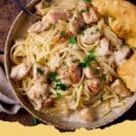 A close-up of creamy Garlic Parmesan Chicken Pasta in a bowl, garnished with fresh parsley and extra Parmesan cheese.