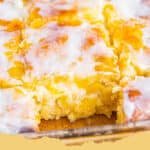 The Easiest & Most Delicious Peach Butter Swim Biscuits You'll Ever Make! 5 Golden brown Peach Butter Swim Biscuits in a baking dish, with juicy peach pieces visible on top.